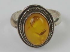 A silver and Baltic amber ring, having rope twist setting, 1.8cm wide, stamped 925, size R-S.