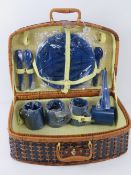 A wicker picnic basket with contents.