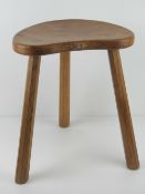 A Robert 'Mouseman' three-legged oak stool.