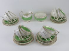 A quantity of twelve late Victorian hand painted green banded rose themed trios together with milk