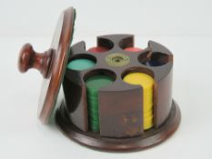 A circular mahogany gaming chip dispenser, 12.5cm dia, complete with six chip stacks within.