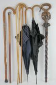 Eight assorted vintage walking sticks and umbrellas, some with silver collars.