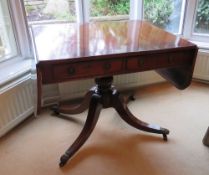 An early 20th century mahogany Georgian style drop leaf table raised over quatreform base