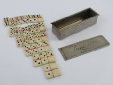 An antique set of miniature carved and stained bone dominoes within original slide top box.