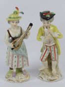 A pair of Continental Musician figurines, each bearing 'N' with crown over to base, 16cm high.