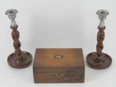 A pair of barley twist oak candlesticks with plated sconces, each measuring 25cm high,