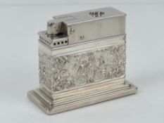 A Mylflam table lighter having repoussé tavern scene upon including musicians and smokers around a