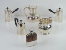 A pair of opposing silver plated hot chocolate pots with ebonised handles,