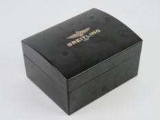 A Breitling black bakelite watch box, contents deficient, 17 x 13.5 x 9.5cm.