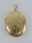A large 9ct gold locket having floral engraving to front, 4.