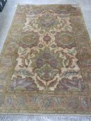 A good heavy woollen and silk rug in muted greens and browns measuring 238 x 154cm.