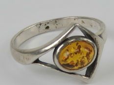 A silver and Baltic amber ring having central oval cabachon in open triangular setting, stamped 925,