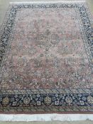 A woollen and silk blush pink ground rug with geometric decoration upon, measuring 242 x 166cm.