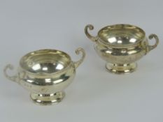 A pair of HM silver salts, each raised over single pedestal foot with twin handles,