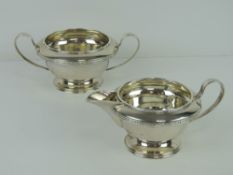An HM silver sugar bowl and cream jug each raised over single foot and hallmarked Sheffield 1933