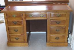 An early 20th century light mahogany kneehole writing desk, plain leather inset surface,