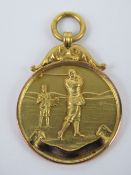 A 9ct gold unengraved golfing themed medallion, hallmarked for Birmingham,