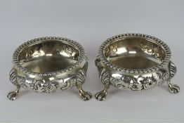 A pair of Victorian HM silver salts having floral decoration and each raised over three lions paw