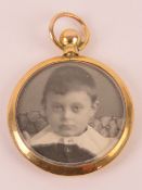 An Edwardian 9ct gold glazed locket having photograph to each side,