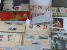 A vintage bluebird luxury biscuit tin containing a quantity of assorted vintage cigarette cards and