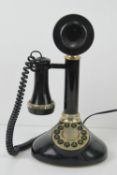 A contemporary black plastic 'candlestick' telephone.
