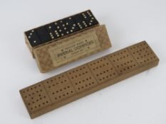 A boxed set of Imperial dominoes together with a vintage cribbage board.