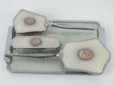 A contemporary chromed dressing table set comprising hairbrush, hand mirror, clothes brush and tray.