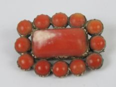 A 19th century red coral mourning brooch having glazed locket to back,