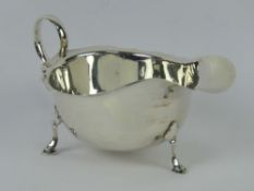An HM silver sauce boat raised over three hoof feet, hallmarked Birmingham 1927, 3.04ozt/94.4g.