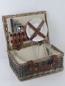 A luxury wicker hamper for two having thermal compartment, ceramic plates, plastic champagne flutes,
