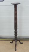 A fine mahogany torchere stand c1900, profusely carved and raised over three pad feet, 140cm high,