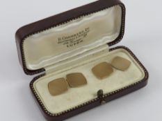 A pair of 9ct gold cuff links having engine turned engraved pattern to front and back within fitted