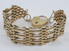 A 9ct gold seven row gate link bracelet with heart padlock clasp, hallmarked 375, 18g.
