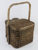 A vintage picnic hamper inc two wine bottle compartments, opening to reveal plastic cutlery, plates,