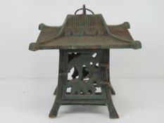 A cast metal candle stand in the style of an Oriental pagoda 26 x 26 x 24cm.