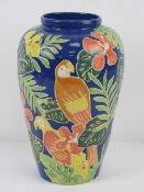 A glazed vase having tropical foliage and parrots upon, 27.5cm high.