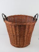 A wicker basket having twin black painted metal handles, all standing 47cm high,