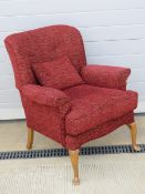 A vintage arm chair re-upholstered in contemporary red fabric, with cushion,