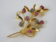 A gilt metal floral brooch set with ruby and sapphire cabachons, no apparent hallmarks,