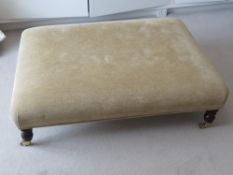 A contemporary large footstool in gold coloured upholstery,