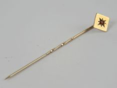 A 9ct gold tie pin having red paste in star setting, hallmarked Birmingham 1964-5.