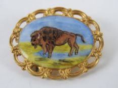 A HM silver and enamel brooch having buffalo upon, gilded, hallmarked for Birmingham with FC Parry