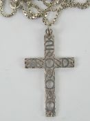 A white metal crucifix pendant having Ce