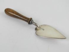 A silver plated masonic trowel having turned wooden handle, 14cm in length.
