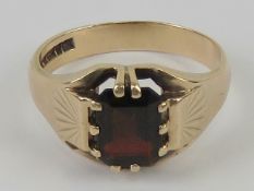 A mens 9ct gold and garnet ring, size U-V, the emerald cut garnet approx 2.24ct (measuring 9 x 6.