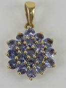 A 9ct gold floral iolite gemstone cluster pendant, hallmarked 375, 2.1cm inc bale.