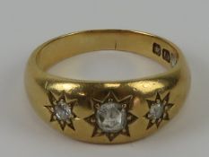 An 18ct gold and diamond gypsy ring, three graduated diamonds in star settings,