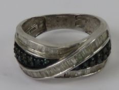 A silver cocktail ring set with blue and white stones, stamped 925, size O.