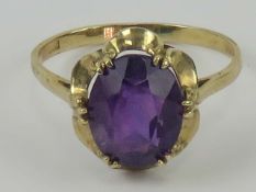 A 9ct gold and amethyst ring, the central oval amethyst of good strong purple hue being approx 1.