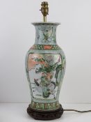 An Oriental vase converted for use as a table lamp, raised over wooden base,